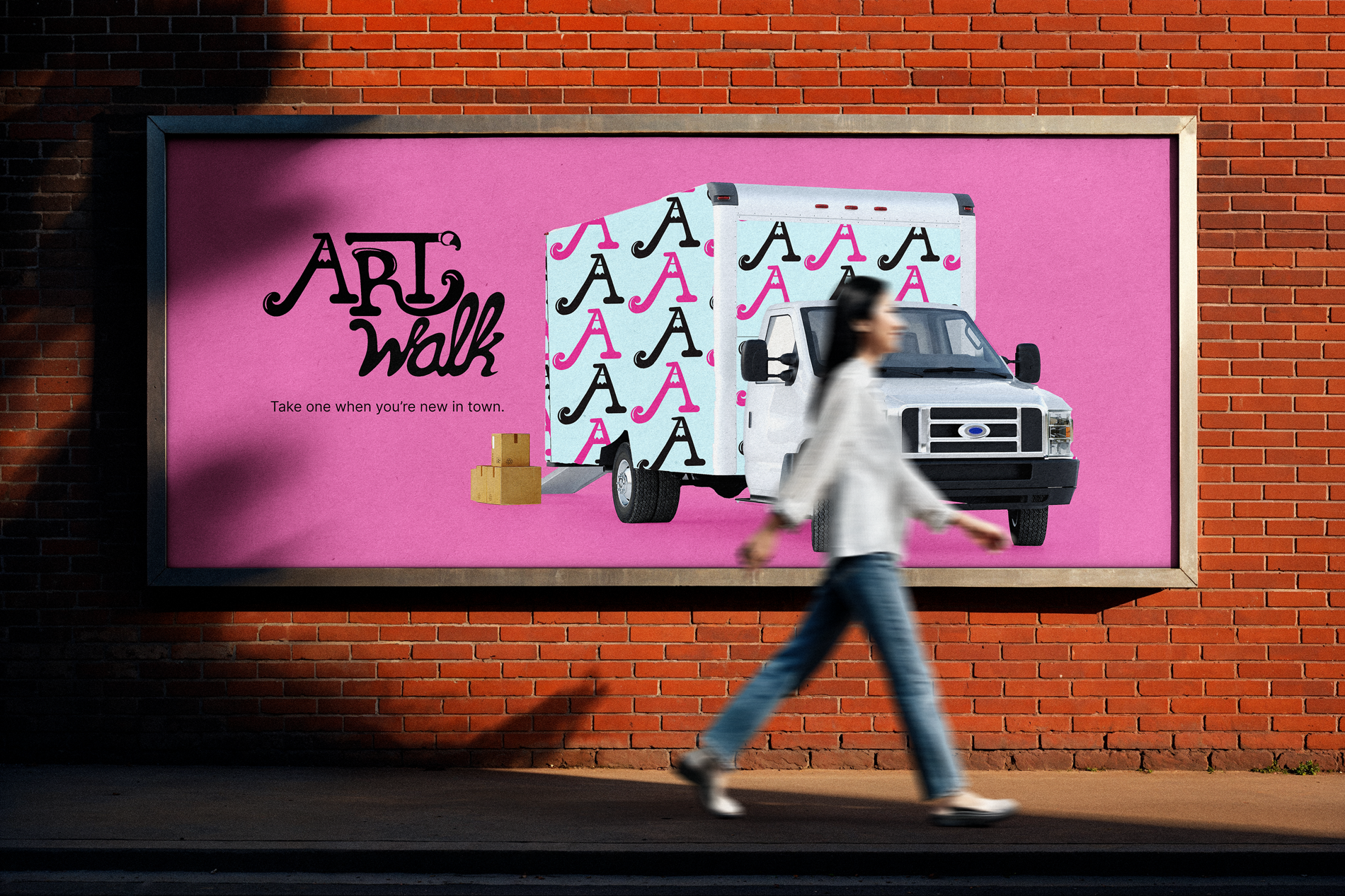 a woman walking past an ArtWalk ad with a moving truck on a pink background on the side of a building